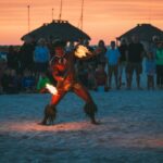 Hombre bailando danza de fuego en la playa durante un festival en Samoa